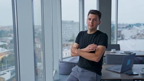 Smiling Man Stands Confidently in Modern City Office