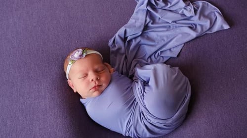 Sleeping Newborn Infant Swaddled in Periwinkle Blanket
