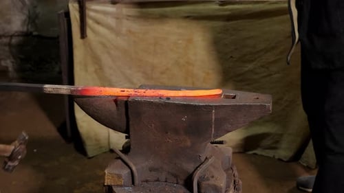 Blacksmith Shaping Hot Metal on Anvil with Hammer