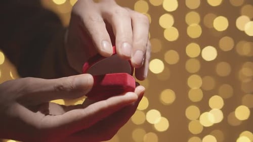 Hands Holding Red Engagement Ring Box Close Up