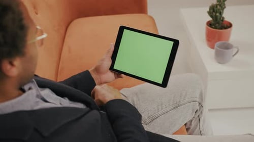 Adult Uses Tablet With Chroma Key Screen