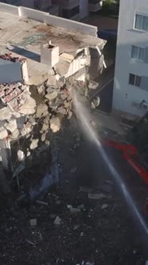 Vertical Video Workers Operate an Excavator with a Hydraulic Hammer to Demolish Old Walls Preparing