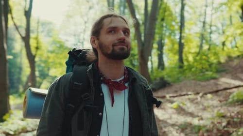 Man Hiking in a Forest Smiling, Green Leaves