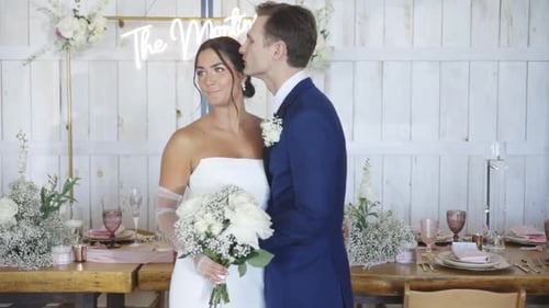 Groom kisses bride on the temple in romantic rustic barn