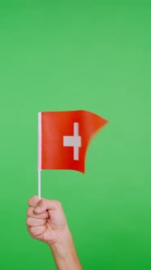Arm Raises Swiss Flag Against Green Screen
