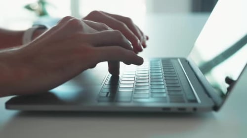 Closeup of Hands of Business Person Typing on Laptop Keyboard at the Desk in Home Office Closeup of