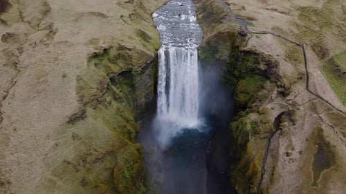 Waterfall Flowing Over Cliff Into River