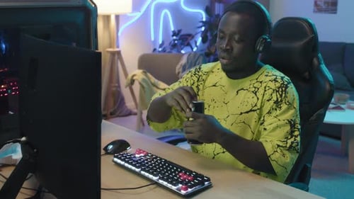 Black Male Gamer Playing and Consuming Energy Drink