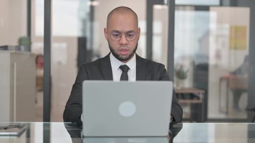 Frustrated Businessman Working on Laptop in Office