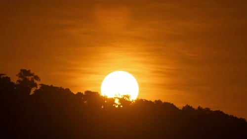 Timelapse of dramatic sunrise with orange sky in a sunny day.