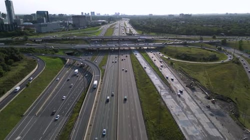 City highway interchange during morning rush hour with transport trucks and automobiles