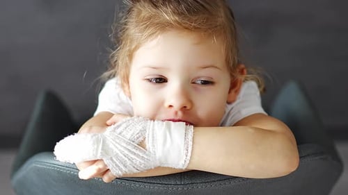 Little Girl with Broken Finger at the Doctor's Appointment in the Hospital