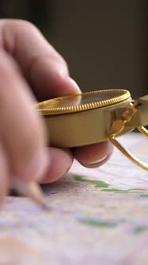 Hand using compass over a map indoors