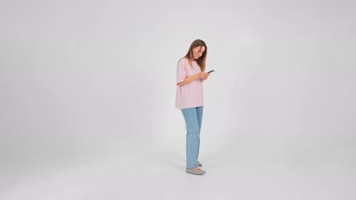 Young Woman Using Phone in White Studio