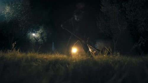 Silhouetted Adult Swinging Tool at Night in Nature