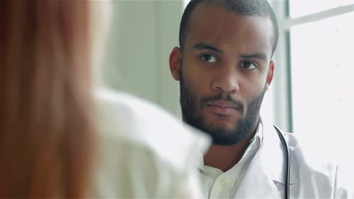 Male Doctor Consulting with Patient in Clinic