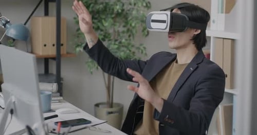 Businessman Using Virtual Reality Glasses Moving Arms Enjoying Cyber Space Sitting at Desk in Office