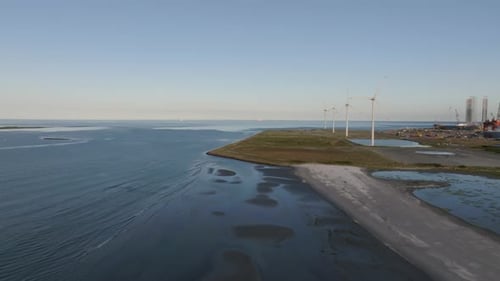 An aerial view, Along the coast, windmills are built, calm and sunny evening.