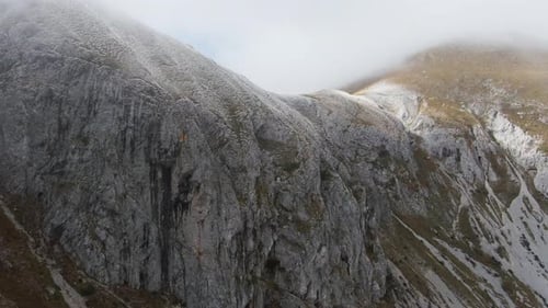 Drone footage of mist sweeping across the mountain’s edge on a brisk autumn morning, revealing natur