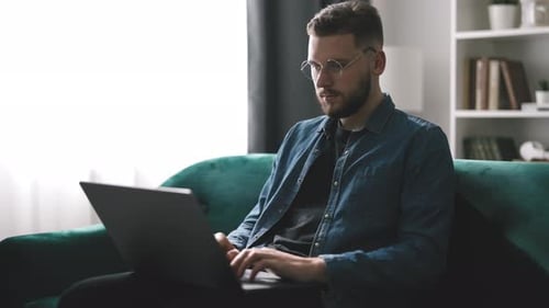 Man Working On Laptop At Home