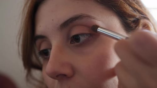 Woman Applying Eyeshadow with Brush in Studio Close-Up