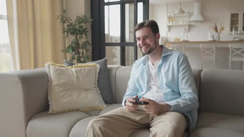 Man Playing Video Games at Home on Couch
