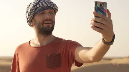 Young Man Taking Selfie Photo with Cellphone on Desert 30s