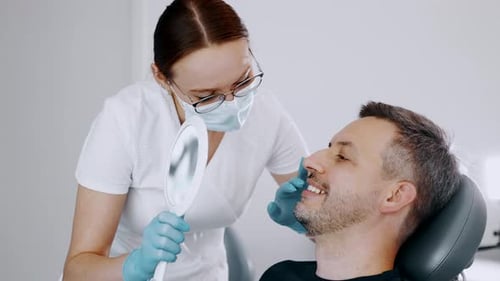 Dentist Showing Man His Teeth in Mirror