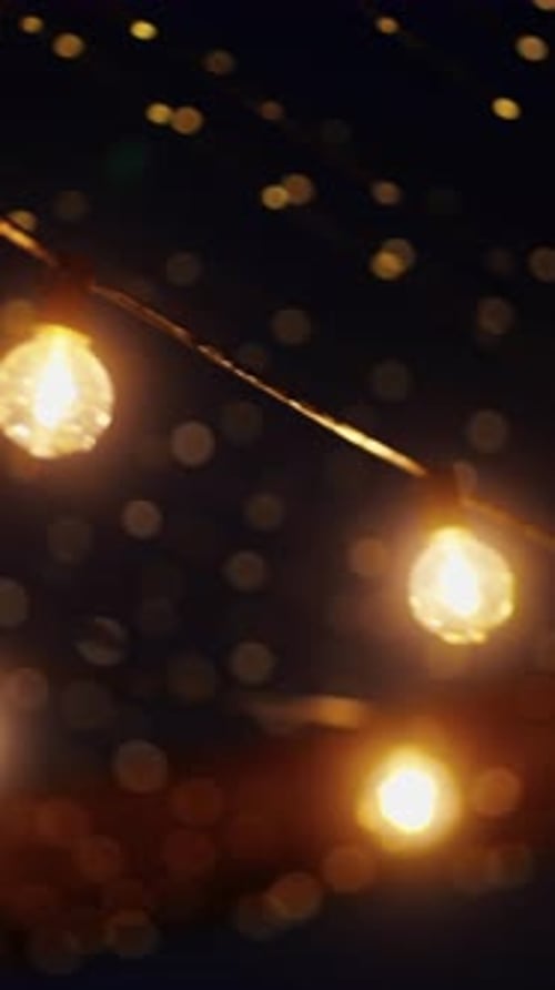 Warm Amber String Lights with Bokeh Against Dark Background
