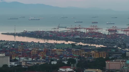 Aerial Footage of Cranes and Stacked Overseas Containers in Cargo Harbor in Morning Revealing Top
