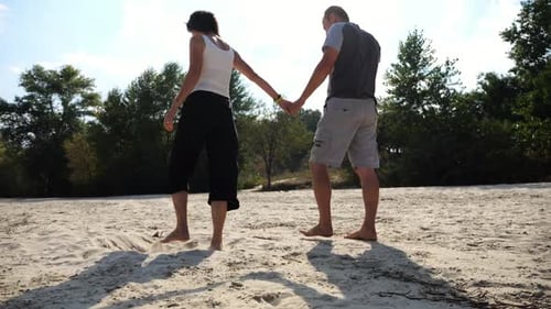 Romantic Couple Holding Hands of Each Other and Walking on Sandy Beach Happy Pair Going Along Coast