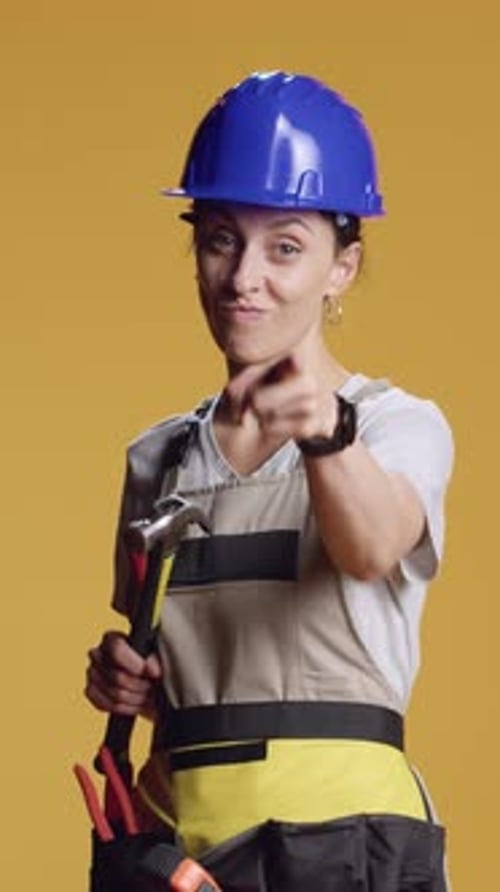 Vertical Video Portrait of Engineer Holding Hammer and Pointing at Camera