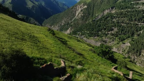 Aerial Panorama of Sunlit Green Hills with Ancient Ruins and Shadows Near Mountain Road Sunlit Hills