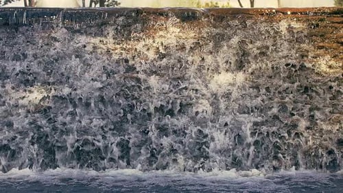 Waterfall Closeup. Falling Water. Waterfall in Sunlight. Water Flowing on Rocks Cascade