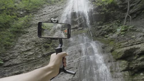 Bottom View of Mountains and Waterfall Through the Smartphone Camera