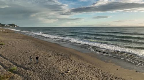 Couple Walking Along the Coast of the Mediterranean Sea Blue Cloudy Sunset