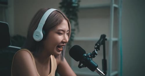 Woman Speaking into Microphone with Headphones Indoors