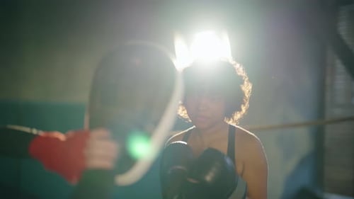Determined Woman Practicing Boxing with Trainer
