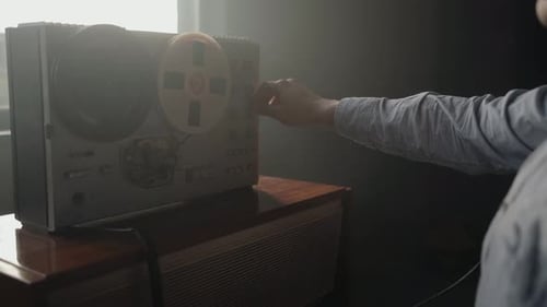 Hand Adjusting Controls on Reel-to-Reel Recorder