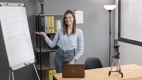 Smiling Woman Presenting Business Information Next to Whiteboard