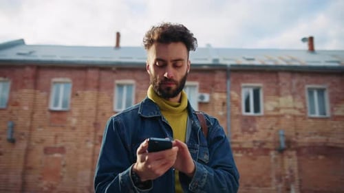 Young Man Using Smartphone in an Urban Setting
