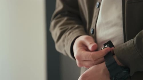 Man Fastening Black Digital Watch on his Wrist