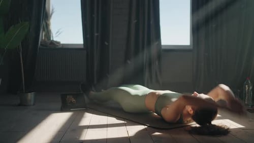 Woman Doing Exercise For Abdominal Muscles Lying On Floor Watching Online Workout With Coach