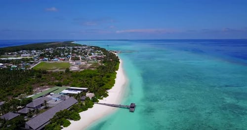aerial view of a resort on the Maldives with white sandy beaches, and deep dark blue sea