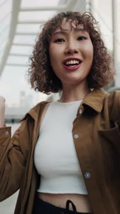 Cheerful Woman Waving in the City