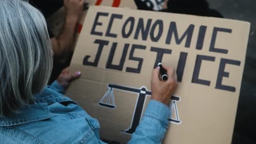 Hochrangige Aktivistin stellt Protestbanner gegen die Finanzkrise auf — Konzept des Aktivismus für wirtschaftliche Gerechtigkeit