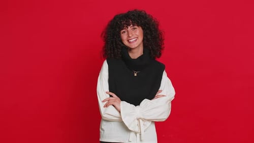 Smiling Woman Posing in Front of Red Background