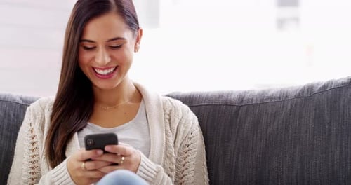 Smiling Woman Using Mobile Phone on Couch