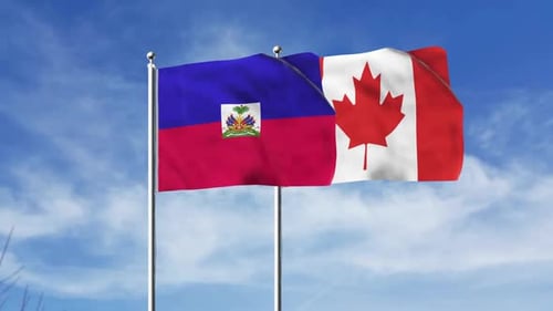 Haiti And Canada Flags Waving Against Blue Sky