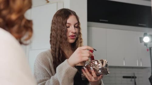 Lippenstift-Display mit dem Schöpfer von Ambient Lighting, der Lippenstift neben dem reflektierenden Spiegel vorführt